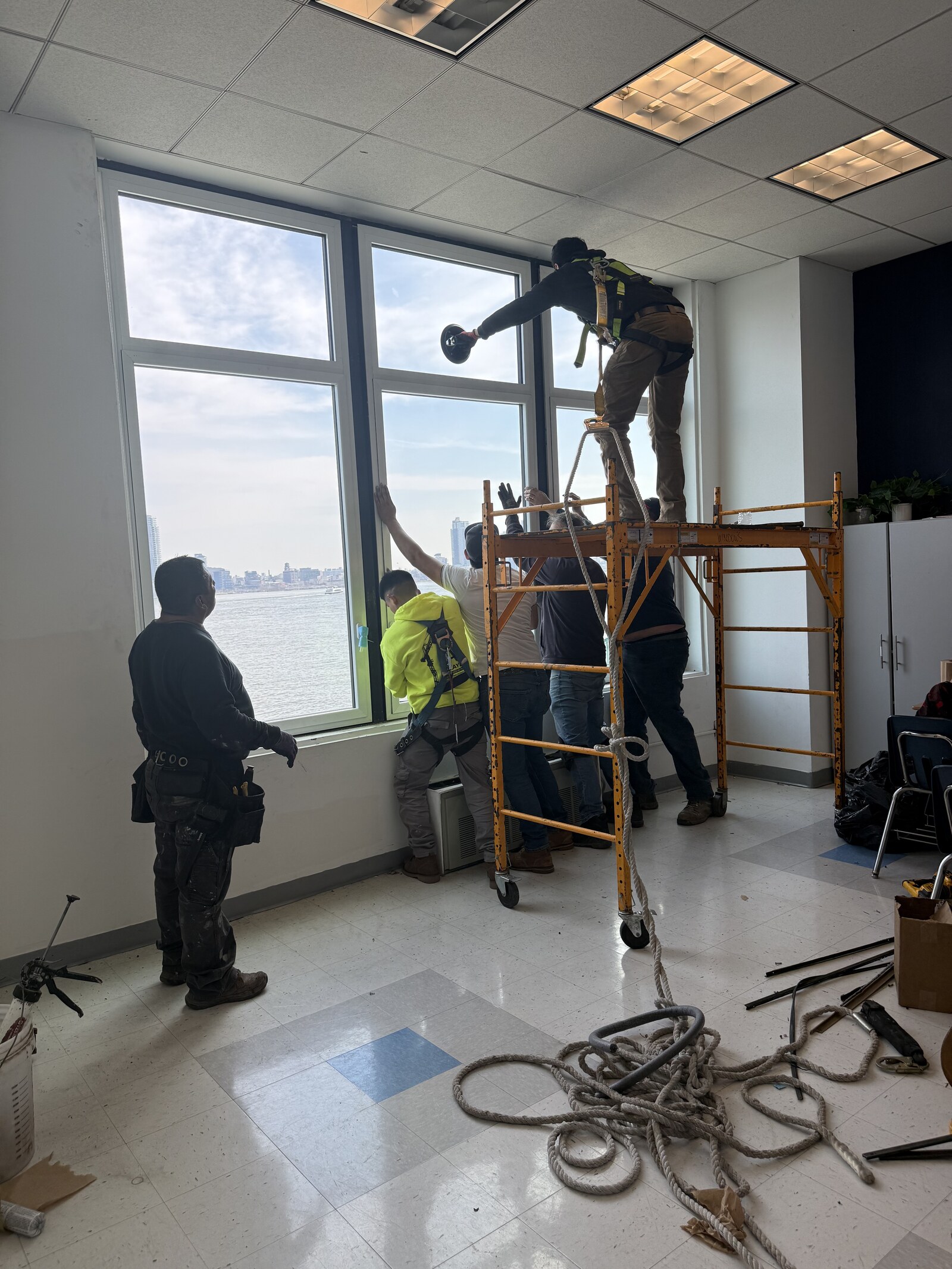 AirGuard crew installing a new floor-to-ceiling window high above the East River